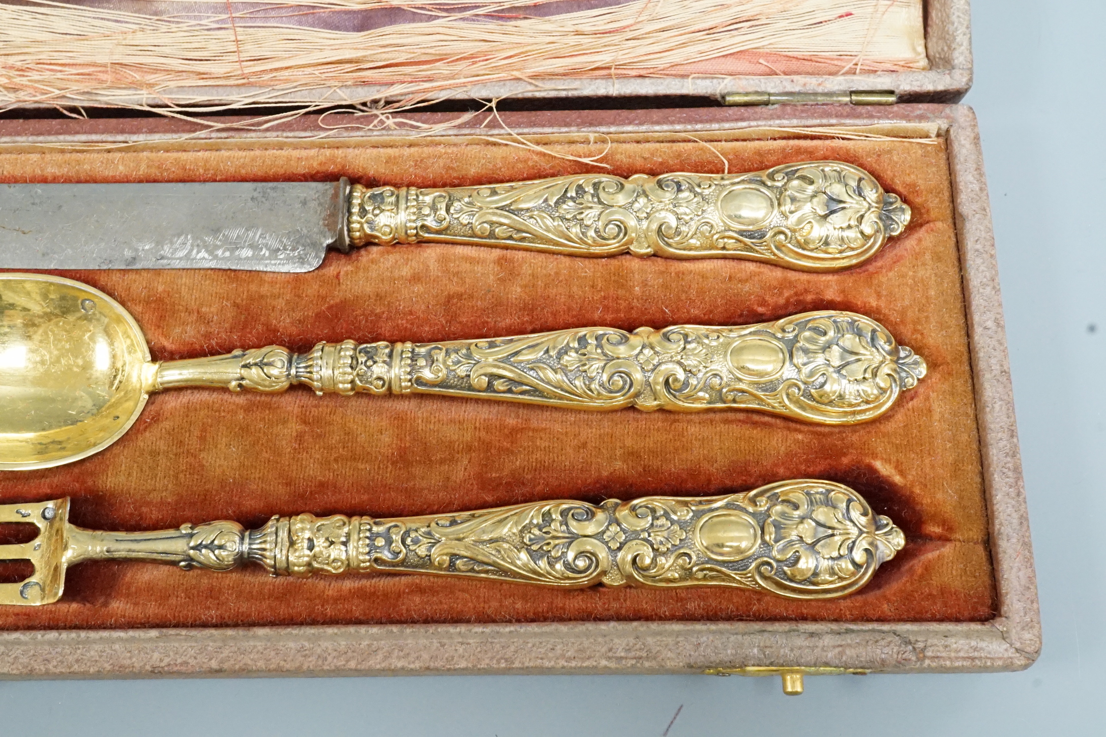A leather cased early 19th century gilt white metal three piece cutlery set, knife 18.1cm.